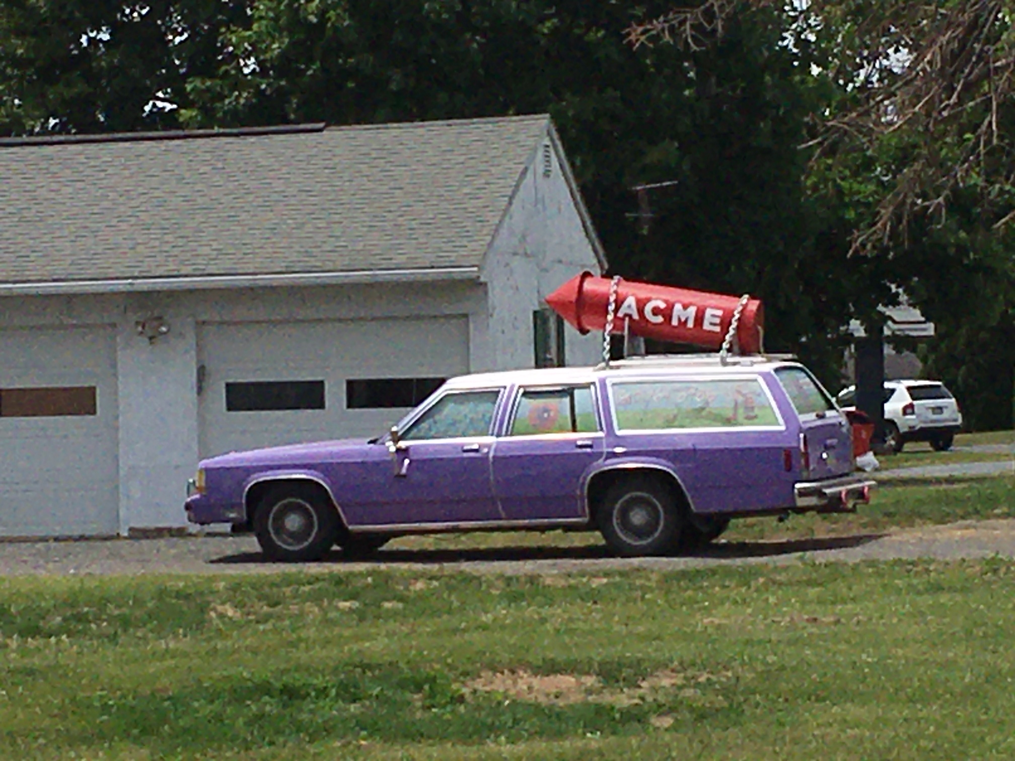 A vintage purple station wagon parked on a lawn